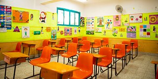 Klassenzimmer mit roten Stühlen und gelb gestrichener Wand