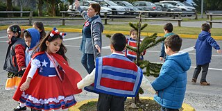 Schulkinder in traditioneller Kleidung tanzen