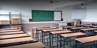 Blick auf ein leeres Klassenzimmer zur Tafel hin