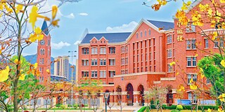 Gebäude der The Affiliated School of Guangzhou Foreign Language School mit Herbstlaub