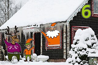 Rentier Matilda und Wichtel Karl winken dem Nikolaus in seiner mit Schnee bedeckten Holzhütte