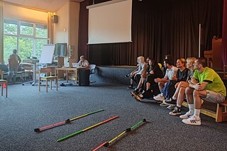 Jugendliche und junge Erwachsene in einer Mehrzweckhalle.