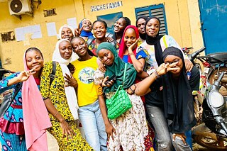 Junge Frauen aus Mali posieren fröhlich vor der Kamera.