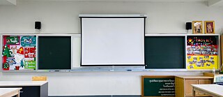 Whiteboard in leerem Klassenzimmer mit Deutschlandplakaten